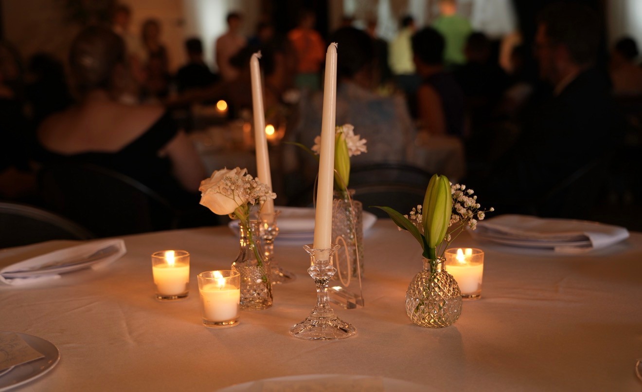 Candlelit reception table with taper candles, votives and small white flowers